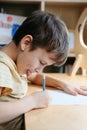 A schoolboy doing math lesson sitting at desk in the children room Royalty Free Stock Photo