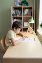 A schoolboy doing math lesson sitting at desk in the children room Royalty Free Stock Photo