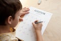 A schoolboy doing math lesson sitting at desk in the children room Royalty Free Stock Photo