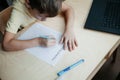 A schoolboy doing math lesson sitting at desk in the children room Royalty Free Stock Photo