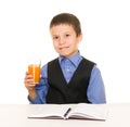 Schoolboy drinks juice at a desk with diary and pen Royalty Free Stock Photo
