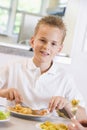 Schoolboy enjoying his lunch in a school cafeteria Royalty Free Stock Photo