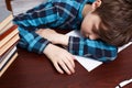 Schoolboy falling asleep while studying at copybook. School life Royalty Free Stock Photo