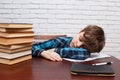 Schoolboy falling asleep while studying at copybook. School life Royalty Free Stock Photo