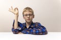 schoolboy with glasses raises his hand. boy in plaid shirt knows answer. Elementary school. Study online from home