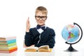 A schoolboy with glasses at a table with books and a globe pulls Royalty Free Stock Photo