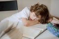 Schoolboy has fallen asleep sitting at a school desk