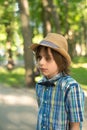 The schoolboy in a hat and tie - butterfly goes on the park. H