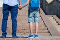 Schoolboy with his father are standing in front of the stairs upward, a boy is wearing a backpack Royalty Free Stock Photo