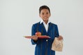 Schoolboy holding apple, books and disposable lunch bag against white background