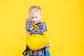 Schoolboy holding backpack  on yellow Royalty Free Stock Photo