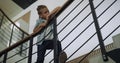 Schoolboy leaning stairs railing looking corridor. Boy standing stairway alone. Royalty Free Stock Photo