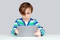 Schoolboy learning at home. Children, technology and education concept. Cute serious kid using digital tablet