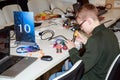Schoolboy making a robot with the electric soldering iron