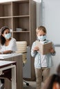 schoolboy in medical mask reading book Royalty Free Stock Photo