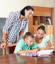 Schoolboy and parents together doing homework