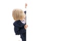 Schoolboy peeking out from behind an empty blank. Blond boy in school uniform with blank white poster board peeking. Copy space Royalty Free Stock Photo