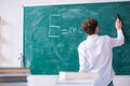 Schoolboy physicist in front of green board Royalty Free Stock Photo