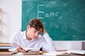 Schoolboy physicist in front of green board Royalty Free Stock Photo