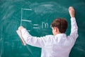 Schoolboy physicist in front of green board Royalty Free Stock Photo