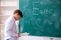 Schoolboy physicist in front of green board Royalty Free Stock Photo
