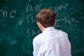 Schoolboy physicist in front of green board Royalty Free Stock Photo