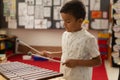 Schoolboy playing xylophone in a classroom