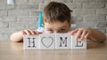 Schoolboy plays with cubes and puts it together in word Royalty Free Stock Photo