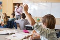 Schoolboy raising hand to answer question in a school class Royalty Free Stock Photo