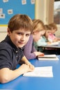 Schoolboy Reading Book In Classroom