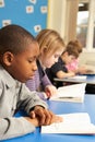 Schoolboy Reading Book In Classroom Royalty Free Stock Photo