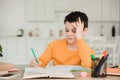 Schoolboy reading book and writing while doing schoolwork at home Royalty Free Stock Photo