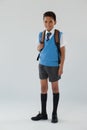 Schoolboy in school uniform with school bag on white background