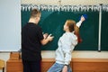 A schoolboy and a schoolgirl at the blackboard. Royalty Free Stock Photo