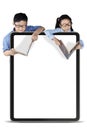 Schoolboy and schoolgirl reading book with board Royalty Free Stock Photo