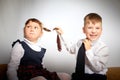 A schoolboy and schoolgirl in uniform having fight, argument, fun and rest in the room. A boy and girl during fun photo Royalty Free Stock Photo