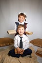 A schoolboy and schoolgirl in uniform having fun and rest with book in the room. A boy and girl during fun photo shoot Royalty Free Stock Photo
