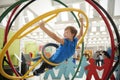 Schoolboy in science centre using human gyroscope, side view Royalty Free Stock Photo