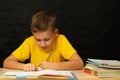 Schoolboy solves homework sitting at the table