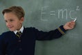 Schoolboy solving maths formula on chalkboard Royalty Free Stock Photo