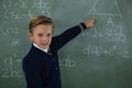 Schoolboy solving maths formula on chalkboard Royalty Free Stock Photo