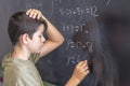 Schoolboy solving a problem on a blackboard. Royalty Free Stock Photo