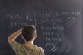 Schoolboy solving a problem on a blackboard. Royalty Free Stock Photo