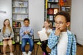 Schoolboy standing in middle of classroom and answering question in front of classmates and teacher Royalty Free Stock Photo