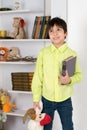 Schoolboy stands with the book and a toy. He remembers the child Royalty Free Stock Photo