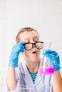 A schoolboy studies multi-colored substances in test tubes, conducts experiments - a portrait on a white background. Concept for Royalty Free Stock Photo