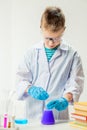 A schoolboy studies multi-colored substances in test tubes, conducts experiments - a portrait on a white background Royalty Free Stock Photo