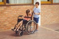 Schoolboy talking to a girl on wheelchair