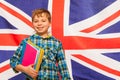 Schoolboy with textbooks against English flag