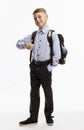 Schoolboy in uniform with a backpack smiles and holds a thumb up. Back to school. Full height. White background. Vertical